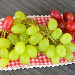 33212487 - nice fresh grapes decorated on a wooden plate and doily