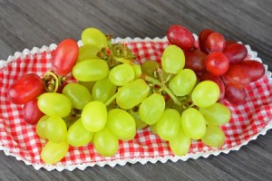 33212487 - nice fresh grapes decorated on a wooden plate and doily